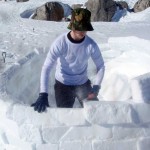 Leo shaping blocks on a half-finished igloo